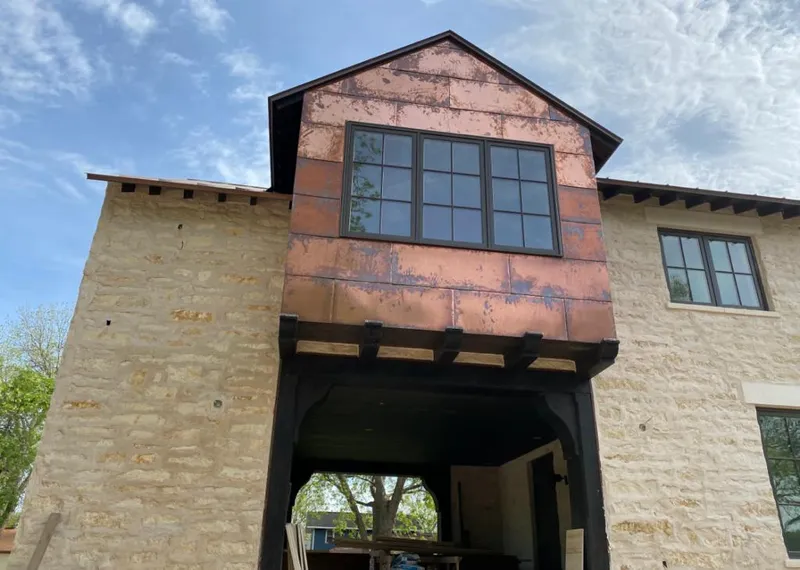 Copper metal panel facade on a stone building for Roof Repair in Roswell